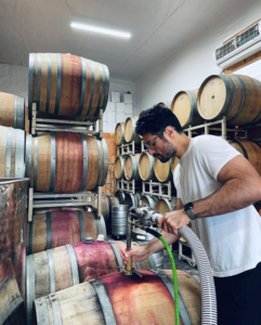 Tom tends to barrels full of red wine with an impressively white t-shirt.